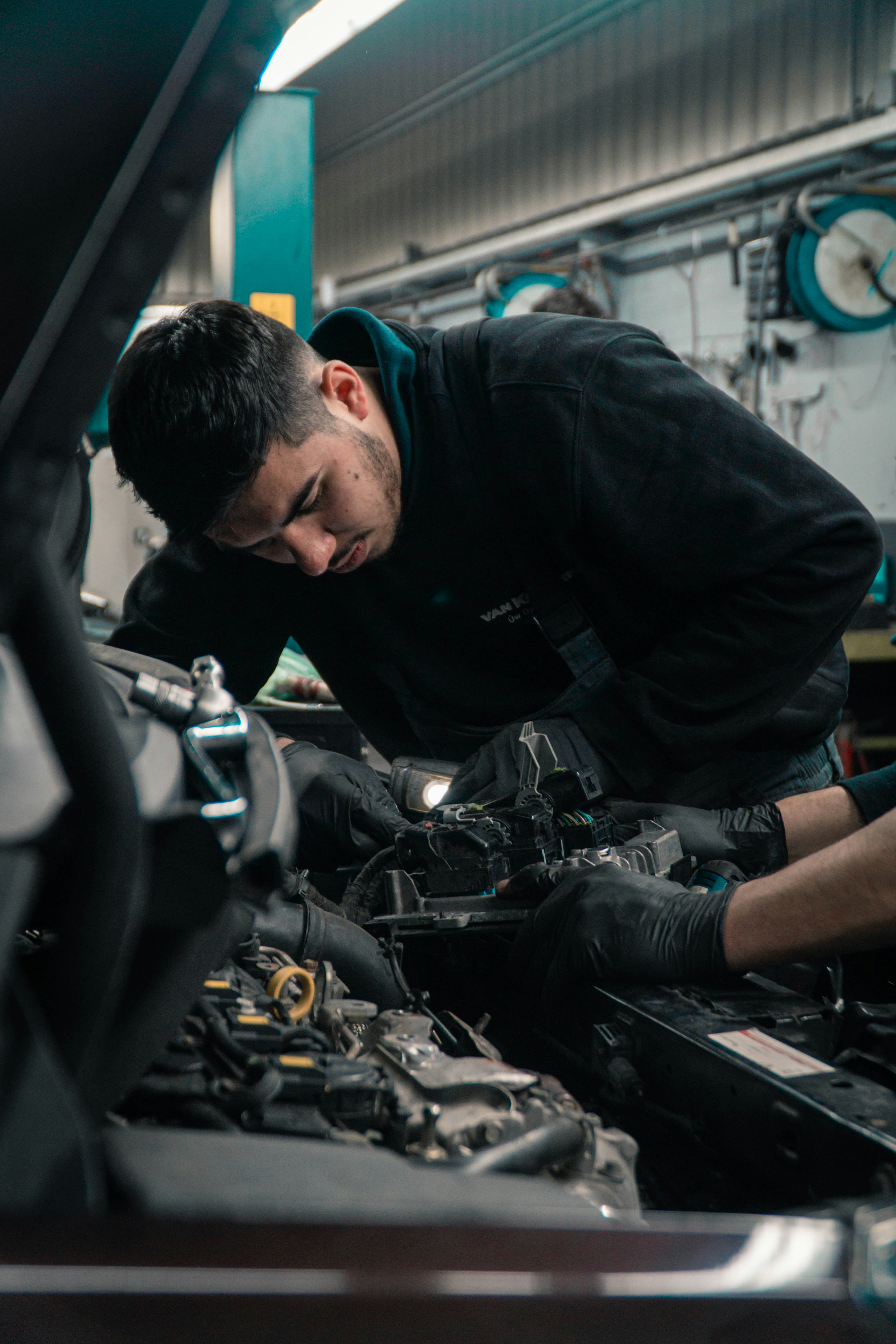 A mechanic hard at work on the engine of a vehicle
