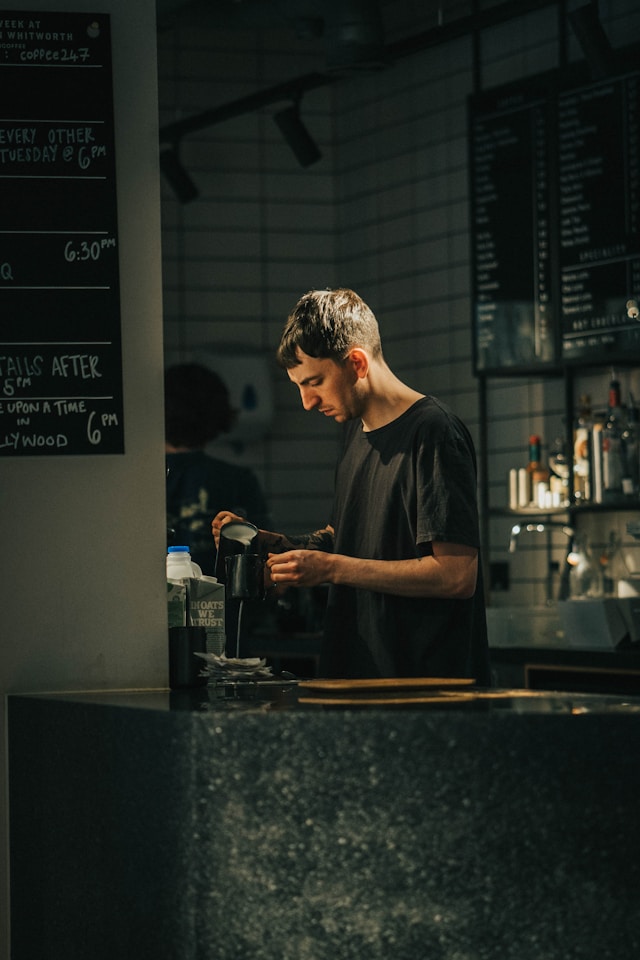 A small business owner standing in front of their storefront
